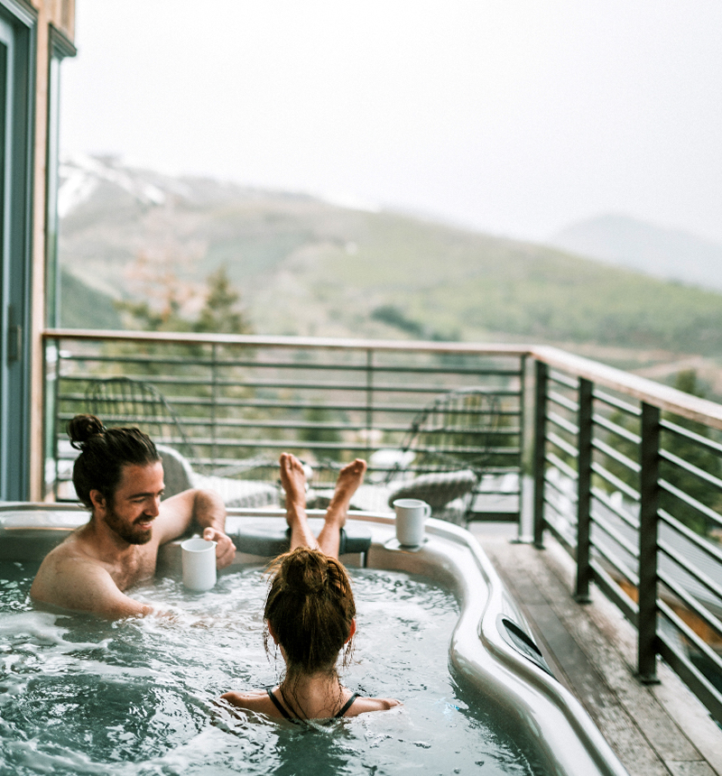 Two people sitting in a hot tub.